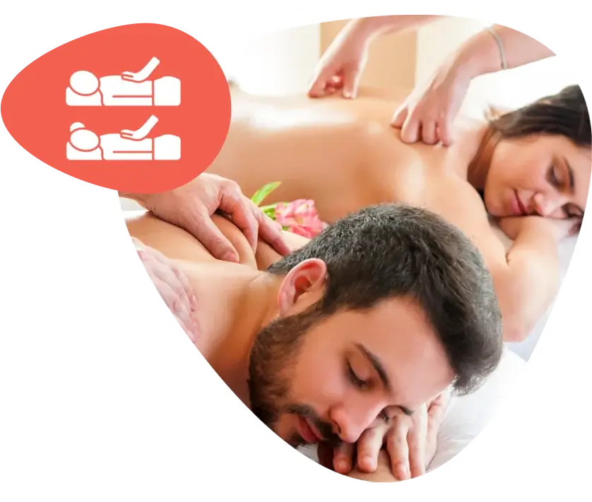 Two people receiving a relaxing couples massage side by side in a spa setting.